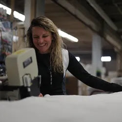 Ashley Pullan flanging a quilted cover, showcasing mattress craftsmanship.
