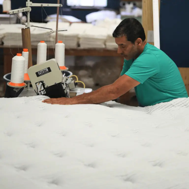 Sewing a custom-size mattress cover, highlighting Jamestown's tailored services.
