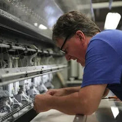 Bruce Pullan operating a quilting machine, demonstrating expertise in mattress making.