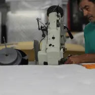 Tape edge machine in action, enhancing the durability of a Jamestown Mattress.